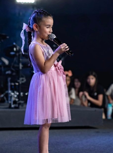 Niña cantando en un recital